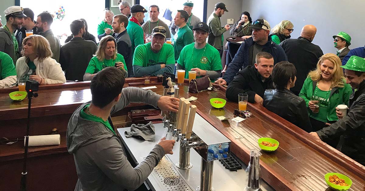 picture of the old bayheads taproom from behind the bar packed full of guests wearing green for saint paddys day.